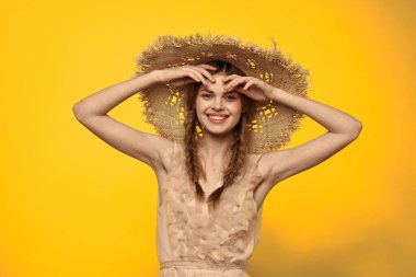 Sarı arkaplan duygularıyla elinde hasır şapkalı bir kadın... 