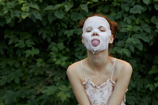 Nette Frau Anti-Falten-Maske Sie lehnte sich nach vorne und streckte ihre Zunge nackten Schultern aus — Stockfoto