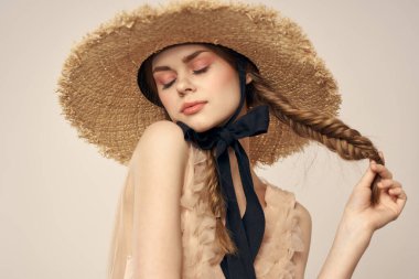 Şapkalı ve arka planda giyinmiş romantik bir kadın elleriyle komik duyguların portresini çiziyor.