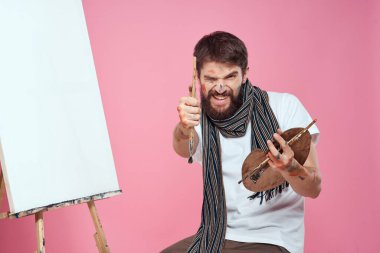 ressam palet tutuyor sanat sehpası çiziyor yaratıcılık hobisi pembe arka plan