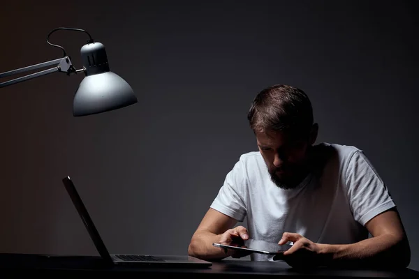 Homem com laptop sentado à mesa fundo escuro no local de trabalho emoções do escritório lâmpada gestual com as mãos modelo corte vista — Fotografia de Stock