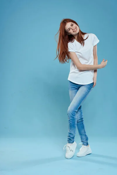 Красива жінка в білій футболці синій джинс способу життя на повному зростанні студія синій фон — стокове фото