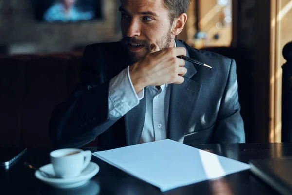 Homme d'affaires assis à une table dans un café documents travailler tasse de café officielle — Photo