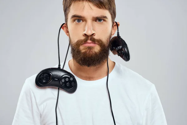 Ein Mann hält zwei Steuerknüppel in der Hand, die Freizeittechnik spielen, weißes T-Shirt — Stockfoto