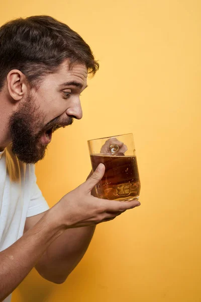 Man med en mugg öl kul alkohol livsstil vit t-shirt gul isolerad bakgrund — Stockfoto