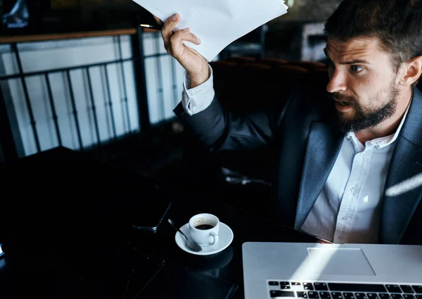 Uomo d'affari in un tailleur davanti a laptop emozioni documenti ufficiali tecnologia — Foto Stock