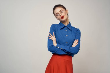 Mavi gömlekli ve kırmızı gözlüklü kadın model. Güzel yüz makyajı stüdyosu.