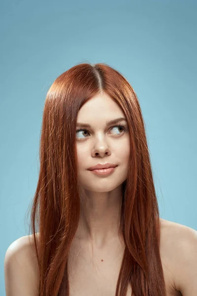Bela morena cabelos longos ombros nus cosméticos charme cuidados de saúde fundo azul — Fotografia de Stock