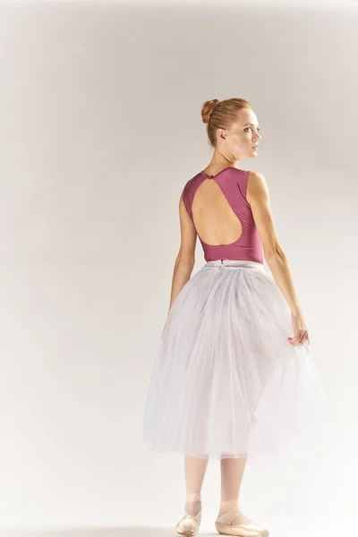 Frau Ballerina in Spitzenschuhen und in einem Tutu auf hellem Hintergrund posiert Beine Tanzmodell — Stockfoto