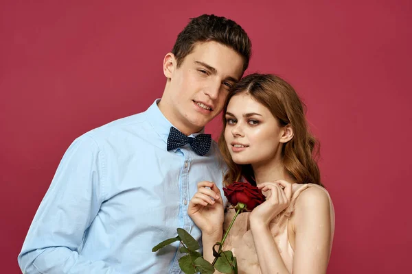 Retrato de pareja romántica enamorada de rosa roja sobre fondo aislado y traje clásico vestido de noche — Foto de Stock