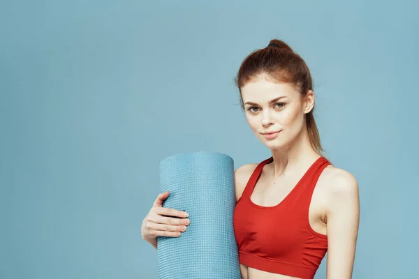 Esteira de treinamento de mulher esportiva em mãos Red tank top exercício fundo azul — Fotografia de Stock