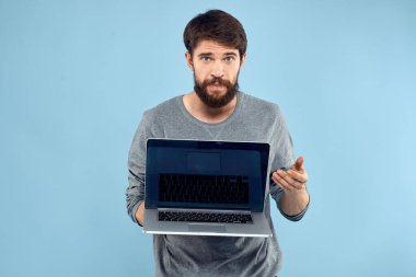 Sakallı adam dizüstü bilgisayarı elinde internet kablosuz teknoloji duyguları mavi arka plan