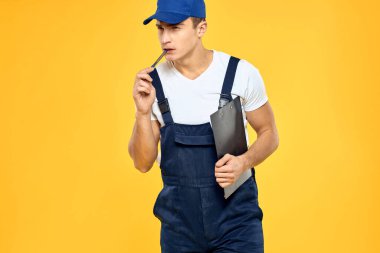Çalışan üniformalı bir adam servis servisi sarı arka planını sunuyor.