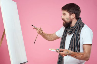 ressam palet tutuyor sanat sehpası çiziyor yaratıcılık hobisi pembe arka plan