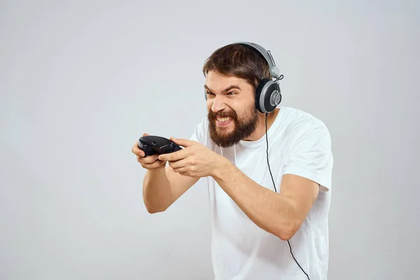 Mann im Kopfhörer mit Gamepad spielt Hobby Unterhaltung Lifestyle Licht Hintergrund — Stockfoto