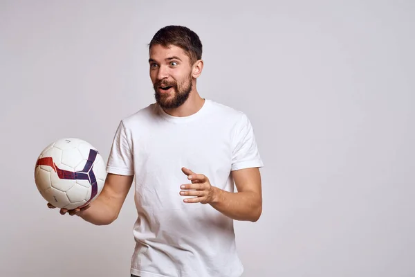 Allenatore maschile con un pallone da calcio in mano su uno sfondo leggero spiegazione energetica dei movimenti — Foto Stock