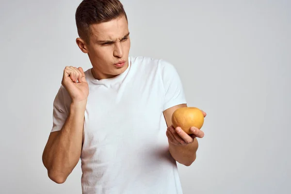 Un hombre con una camiseta naranja y una blanca sobre un fondo claro recortada vista de la modelo — Foto de Stock