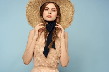 Gri arka planda hasır şapkalı romantik bir kız ve bej renkli bir elbise siyah kurdele duygu modeli.