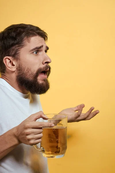 ビールの楽しいアルコールライフスタイルのマグカップを持つ男白Tシャツ黄色隔離された背景 — ストック写真