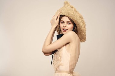 Şapkalı ve arka planda giyinmiş romantik bir kadın elleriyle komik duyguların portresini çiziyor.