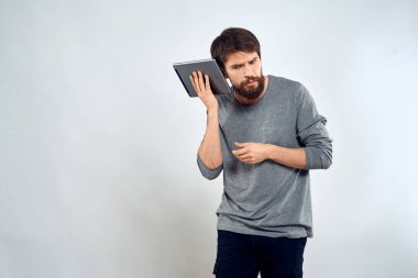 Elinde tablet, elinde internet teknolojisi olan bir adam. İletişim teknolojisi. Gri ceketli.