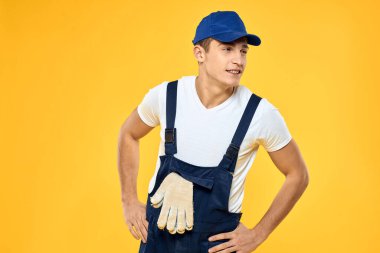 Çalışan üniformalı adam duygularını servis hizmeti sarı arka planda sunuyor