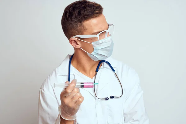 Лікар в медичній сукні зі стетоскопом і окулярами на світлому фоні обрізаний портрет — стокове фото