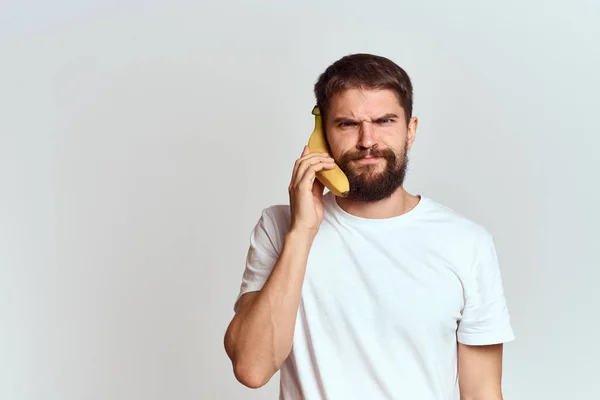 Hombre alegre con un plátano en sus manos sobre un fondo claro emociones divertidas Vista recortada Copiar Espacio — Foto de Stock