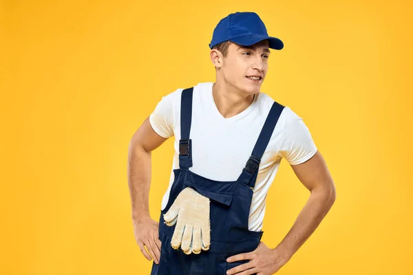 Homme en uniforme de travail émotions rendant le service de prestation de services fond jaune — Photo