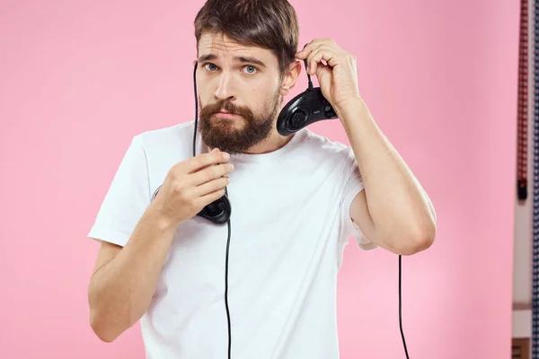 Man met twee joysticks in handen leuk spel technologie lifestyle roze achtergrond — Stockfoto
