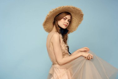 Şapkası ve elbisesi olan kadın duyguları hafif kumaş neşesini büyülüyor.