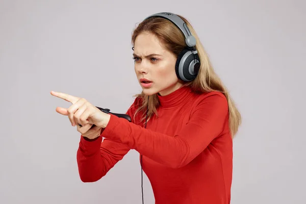 Mujer con auriculares Joystick en las manos jugando juegos diversión ocio estilo de vida entretenimiento camisa roja fondo gris —  Fotos de Stock
