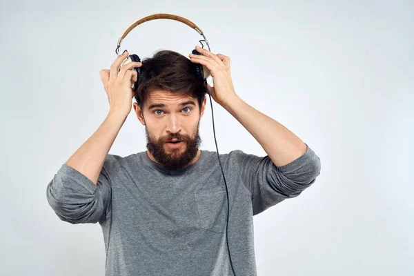 Man in hoofdtelefoon luistert naar muziek levensstijl moderne stijl technologie lichte achtergrond — Stockfoto