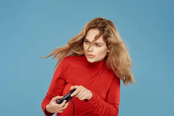 Mulher bonita gamepad em mãos jogando jogos de entretenimento consoles para estilo de vida azul fundo vermelho jaqueta — Fotografia de Stock