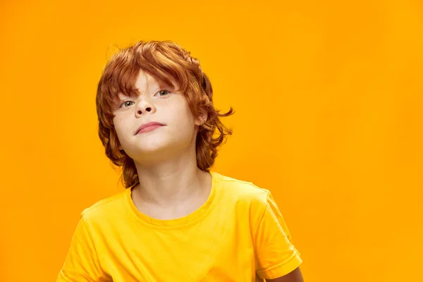 Snygg rödhårig pojke i gul t-shirt beskärda utseende — Stockfoto