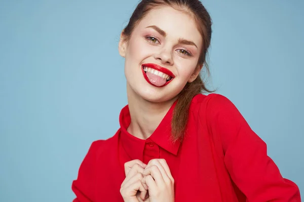 Una ragazza in abiti luminosi mostra un cuore con le mani su uno sfondo blu vista ritagliata — Foto Stock