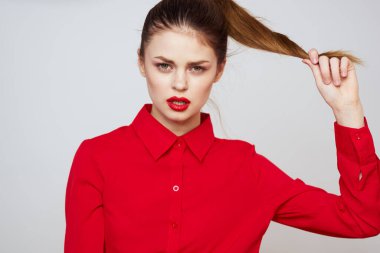 Açık arkaplanda kırmızı dudaklı bir kadının portresi. Makyaj modeli.