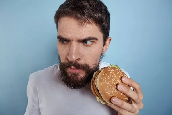 Emotionale Mann Hamburger Fast Food Diät Nahrung Nahaufnahme blauer Hintergrund — Stockfoto