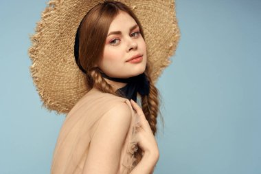 Gri arka planda hasır şapkalı romantik bir kız ve bej renkli bir elbise siyah kurdele duygu modeli.