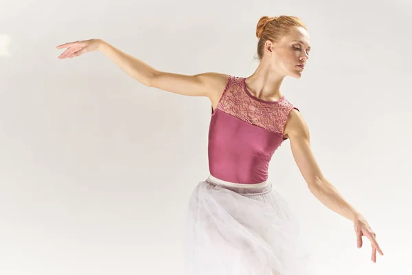 Femme ballerine en pointe chaussures et dans un tutu sur un fond clair pose posant jambes modèle de danse — Photo