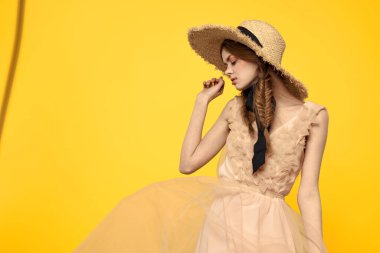 Sarı arka planda kırmızı örgülü kadın portresi.