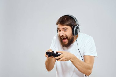 Gamepad 'li kulaklıklı bir adam hobi hayatı tarzı hafif arka planda oynuyor.