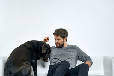 Kanepede evcil köpeği olan bir adam. Arkadaşlarıyla eğleniyor.