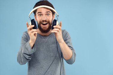 Kulaklık takan adam müzik, duygu, yaşam tarzı modern tarz, mavi arka plan.