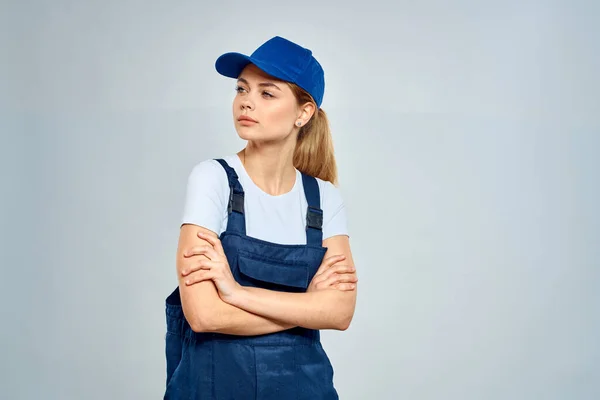 woman in work uniform blue cap service delivery service light background