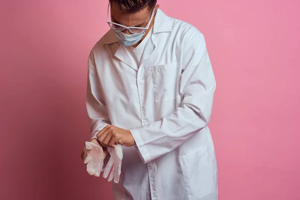 医師です医療手袋顔マスクピンクの背景に切り取られたビュー — ストック写真