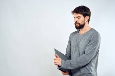 Gri kazaklı bir adam dizüstü bilgisayarlı. Yaşam tarzı teknoloji iletişimi internet işi yapıyor.