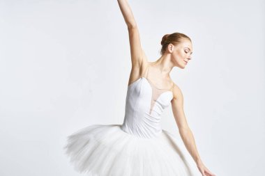 Beyaz etekli balerin dans egzersizi yapıyor. Esnek arka plan.