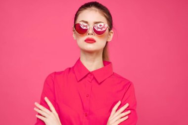Pembe gömlekli ve kahverengi gözlüklü kadın kırpılmış görünüm modeli duyguları el hareketleriyle resim yapıyor.