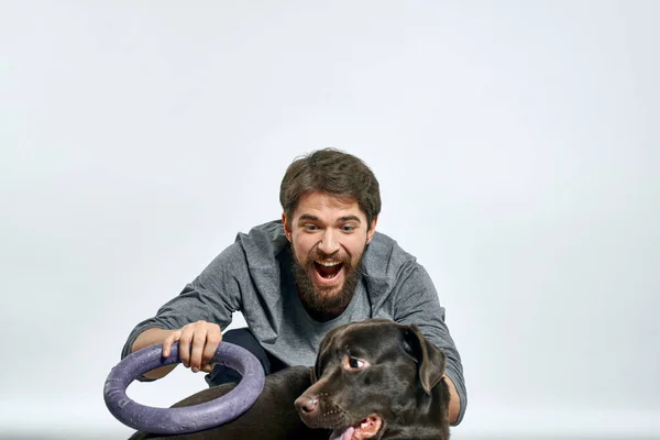 Feliz propietario con mascota negro perro entrenamiento modelo emociones — Foto de Stock